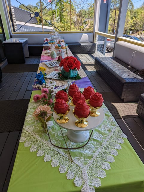 a long table with cupcakes and flowers on it